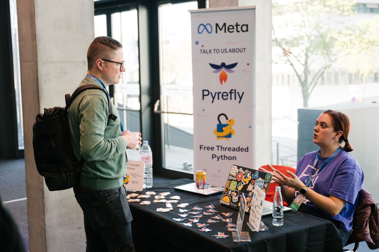 An attendee in conversation with a sponsor team member at their booth